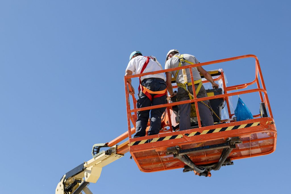 Safety worker operating articulated boom lift inside multi-level construction site-Boom Lift Certification