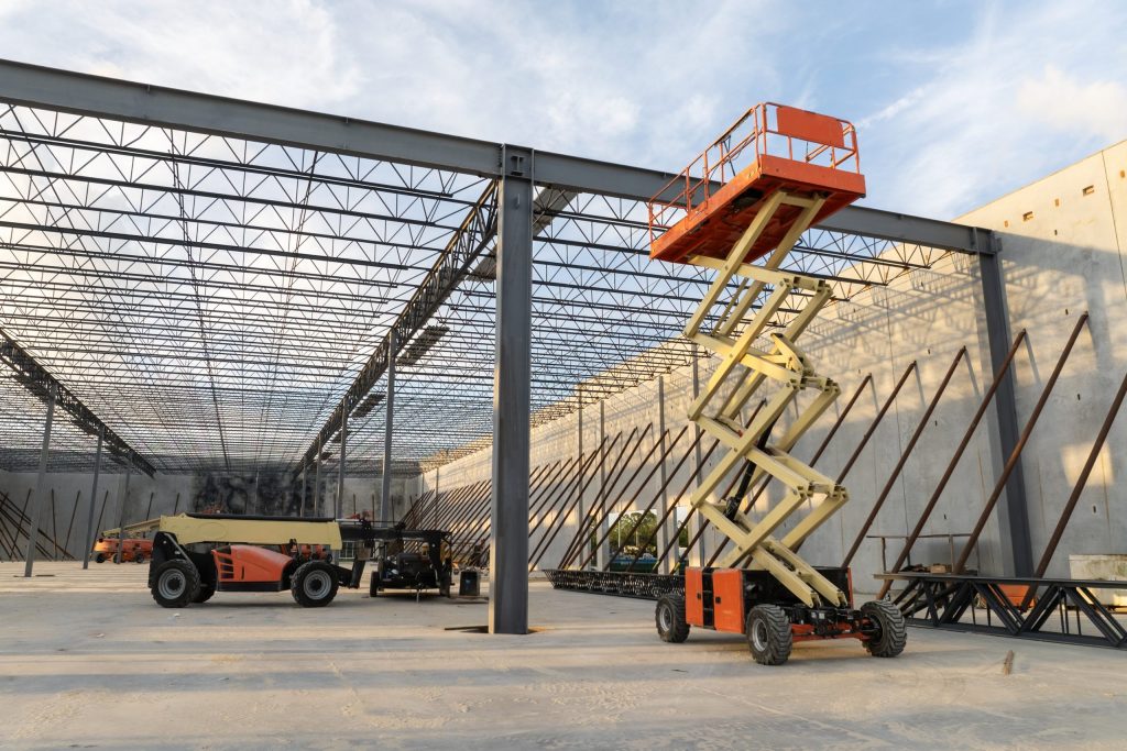 Aerial work platforms at large-scale construction project with metal truss roof system-Scissor Lift Certification