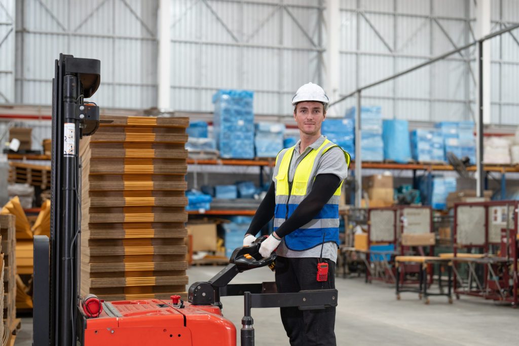 Warehouse worker operating pallet stacker with safety gear-Warehouse Forklift Certification
