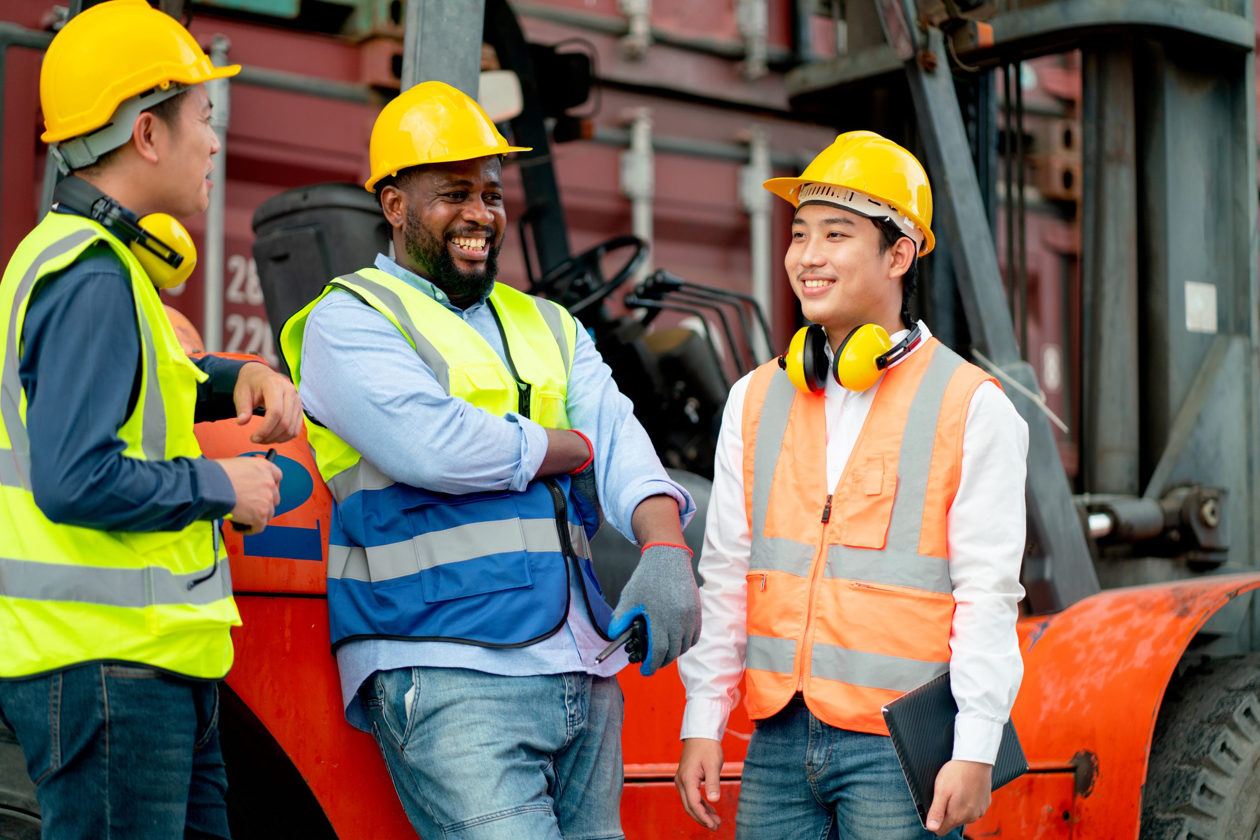 Workers in safety gear standing beside a forklift after completing forklift certification and warehouse forklift training